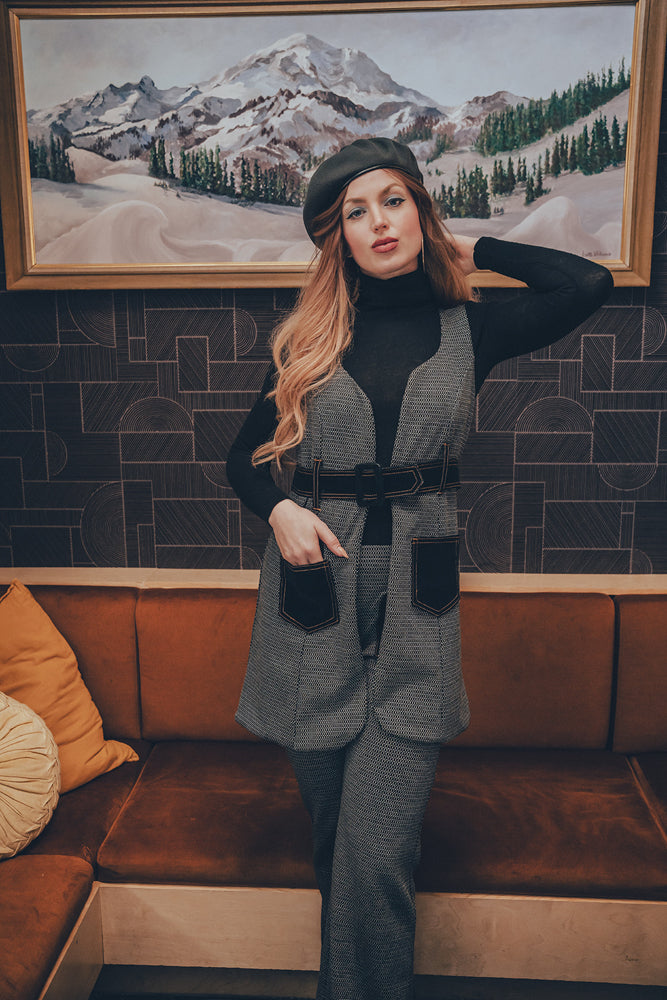 Woman wearing a 1970s retro set in a vintage 70s-style living room, showcasing bold, 70s-inspired fashion and sustainable, ethical small-batch design.