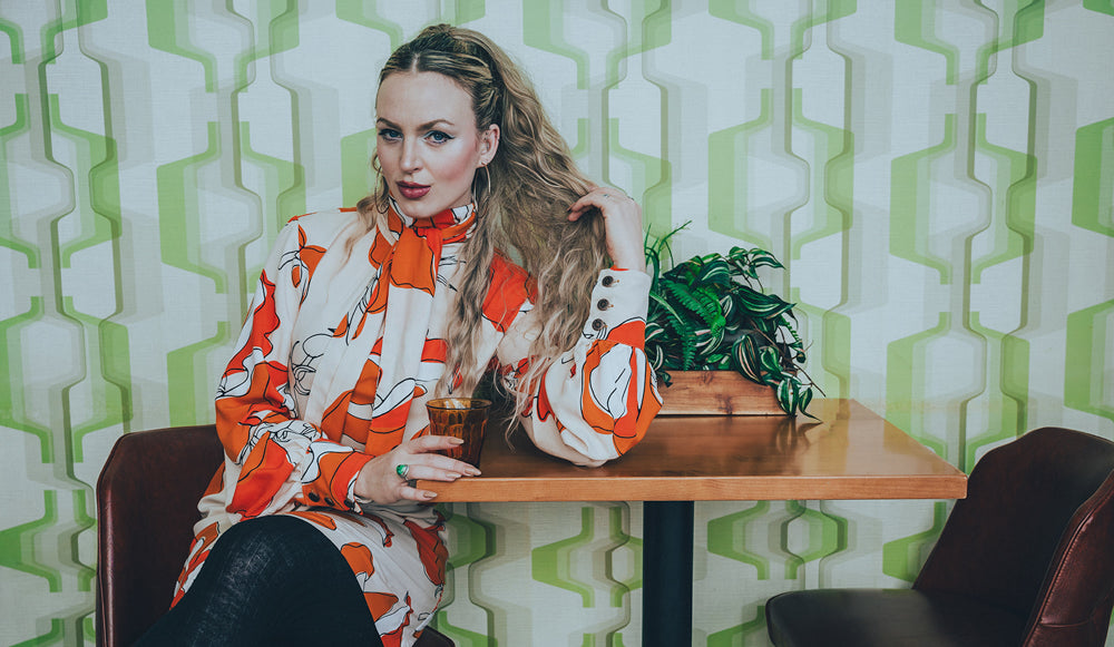 Groovy dress on beautiful woman with retro wallpaper in the background