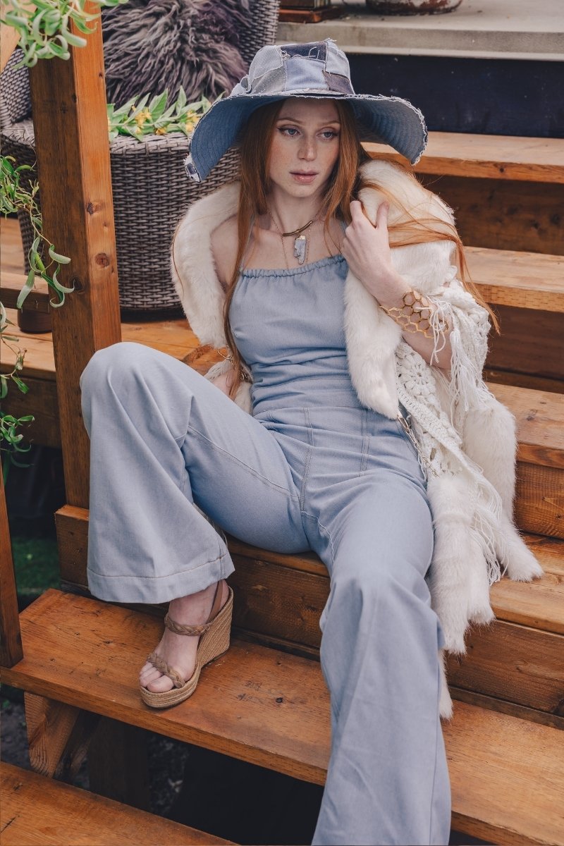  Woman wearing a 70s vintage inspired denim jumpsuit with flared legs and a patchwork hat handmade in small batches by soul sister since 1969