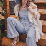  Woman wearing a 70s vintage inspired denim jumpsuit with flared legs and a patchwork hat handmade in small batches by soul sister since 1969