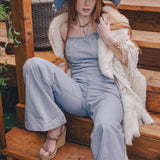  Woman wearing a 70s vintage inspired denim jumpsuit with flared legs and a patchwork hat handmade in small batches by soul sister since 1969
