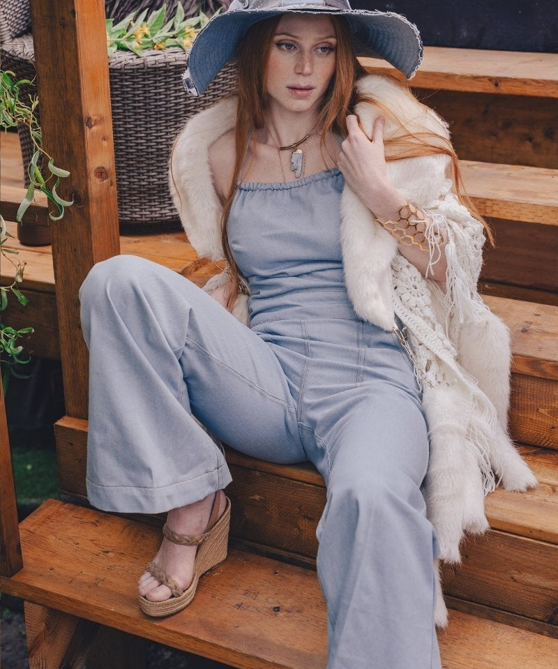  Woman wearing a 70s vintage inspired denim jumpsuit with flared legs and a patchwork hat handmade in small batches by soul sister since 1969