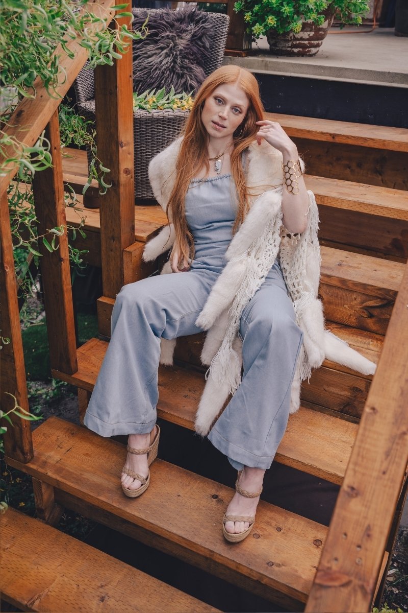 Woman wearing a 70s vintage inspired denim jumpsuit with bell bottom legs handmade in small batches by soul sister since 1969