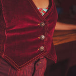 Close-up of a merlot velvet vest with floral patterned lining.