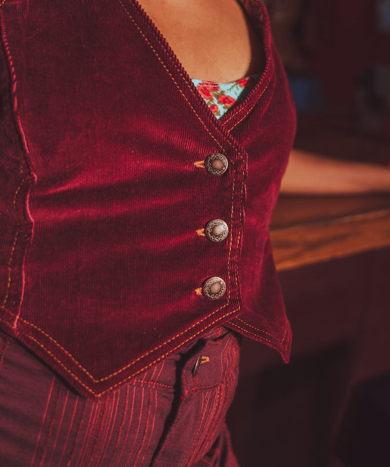 Close-up of a merlot velvet vest with floral patterned lining.