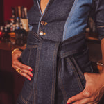Person wearing a denim 70s iconic jumpsuit with a belt in a bar setting