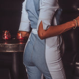 Person wearing a denim outfit in a dimly lit room with red lighting.