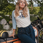 Woman sitting on a motorcycle wearing a peace sign t-shirt with a scenic background Woman wearing a peace symbol shirt with text outdoors wearing Soul Sister since 1969