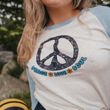 Person wearing a shirt with a peace symbol and text outdoorsWoman wearing a peace symbol shirt with text outdoors wearing Soul Sister since 1969