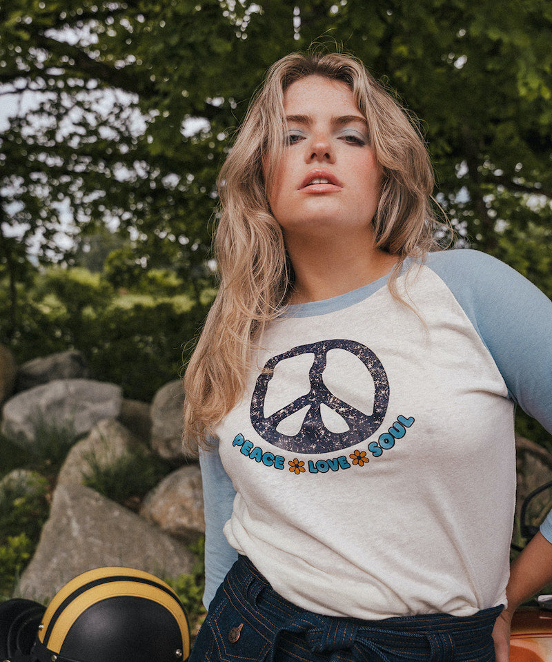 Woman wearing a peace symbol shirt with text outdoors wearing Soul Sister since 1969