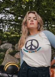 Woman wearing a peace symbol shirt with text outdoors wearing Soul Sister since 1969