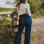 Person standing next to a motorcycle in a natural settingWoman wearing a peace symbol shirt with text outdoors wearing Soul Sister since 1969