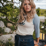 Woman standing outdoors with a scenic background wearing Soul Sister since 1969.