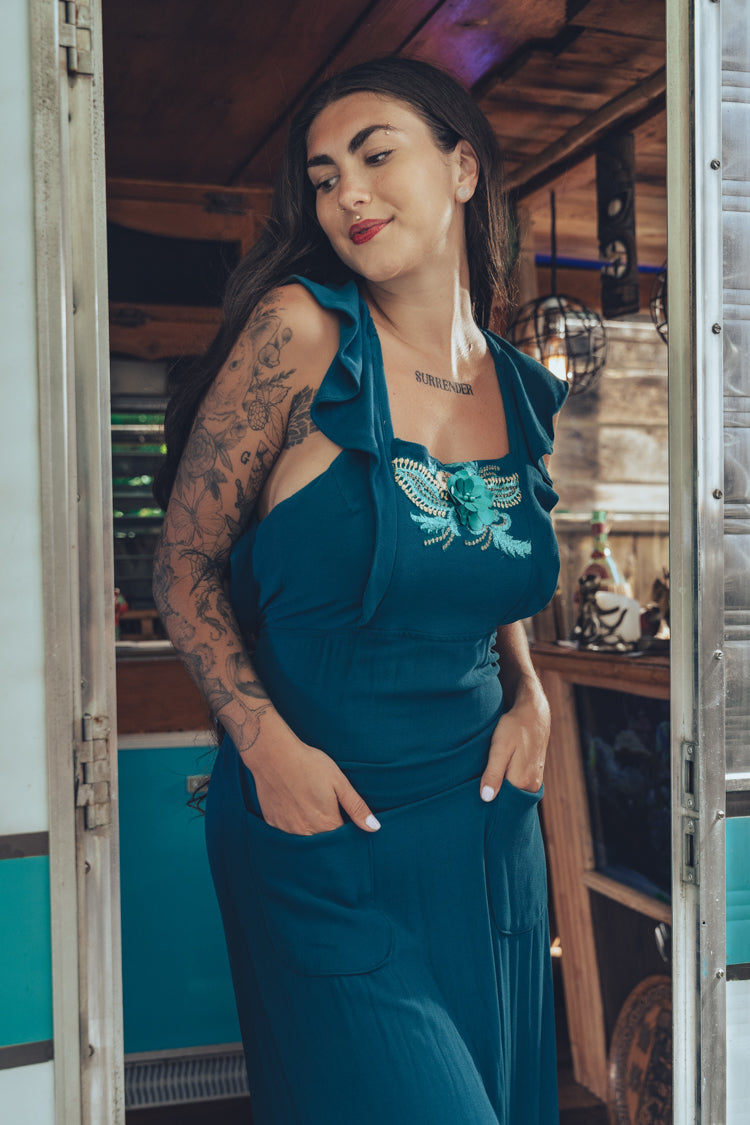 beautiful bohemian embroidered blue dress on woman in a retro trailer