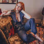 Woman sitting on a couch in a room with posters on the wall