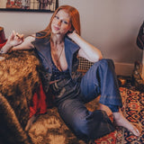 Woman sitting on a couch in a room with posters on the wall
