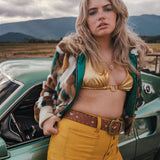 Woman in a vintage outfit standing next to a classic car with mountains in the background wearing soul sister since 1969
