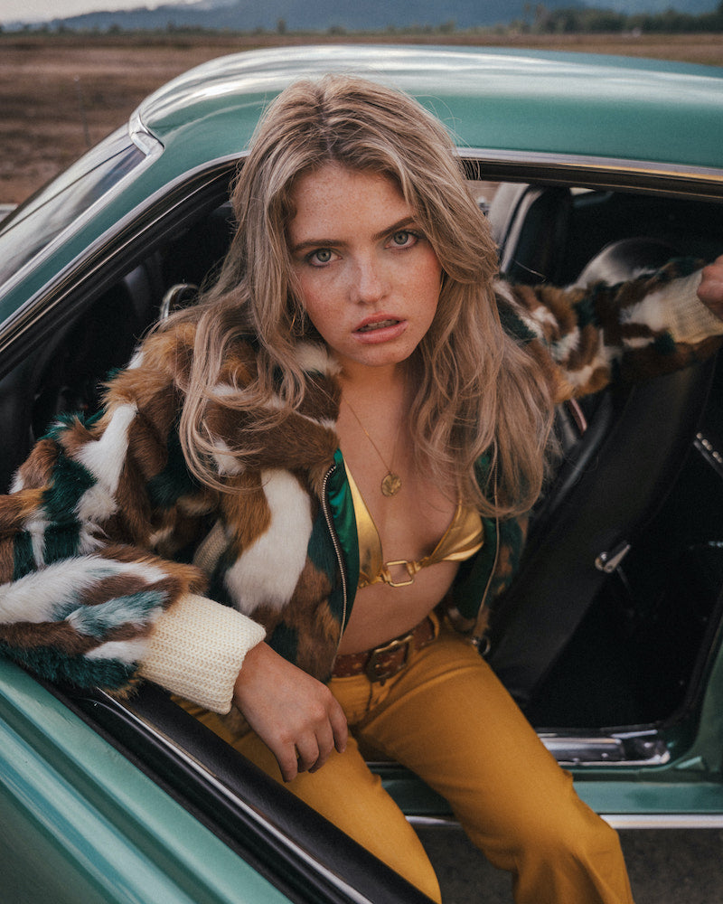 Woman sitting in a vintage car with a scenic background wearing soul sister since 1969 wearing soul sister since 1969
