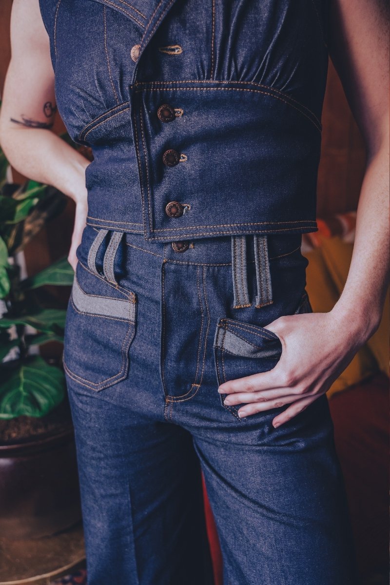 Person wearing a blue denim outfit with a vest and pants.