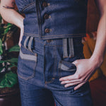 Person wearing a blue denim outfit with a vest and pants.
