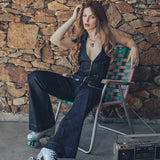 Detail short of a backless halter denim jumpsuit highlighting it open back oversize collar curved and small batch craftsmanship