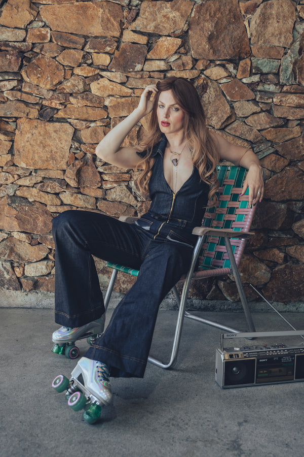 Detail short of a backless halter denim jumpsuit highlighting it open back oversize collar curved and small batch craftsmanship