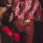 Person wearing a patterned red jacket and red pants with a blurred background