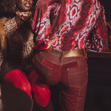 Person wearing a patterned red jacket and red pants with a blurred background