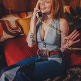 Woman sitting on a couch talking on a phone in a cozy room.