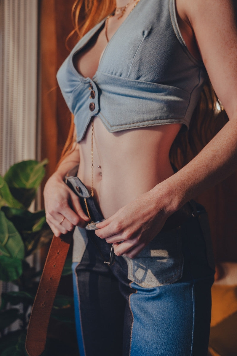Person wearing a denim crop top and jeans with a blurred background