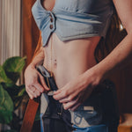 Person wearing a denim crop top and jeans with a blurred background