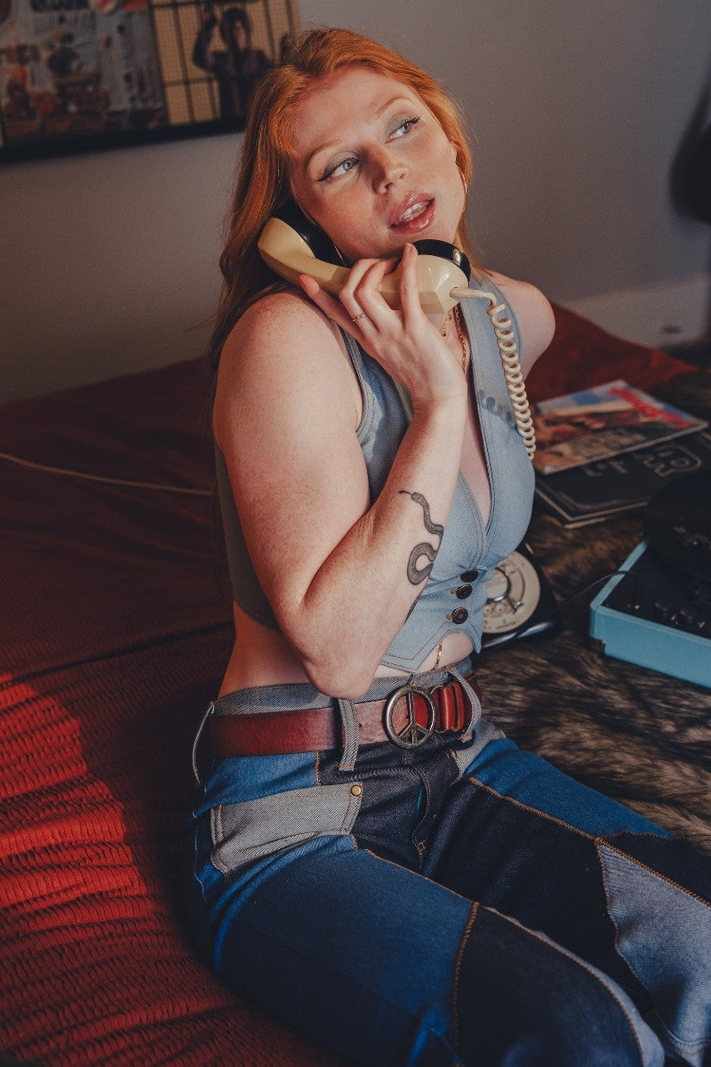 Person in a costume sitting on a couch with a phone to their ear