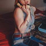 Person in a costume sitting on a couch with a phone to their ear