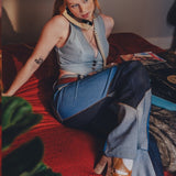 Woman sitting on a red couch with a phone to her ear, surrounded by vinyl records and a plant.