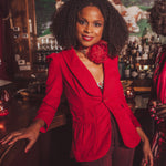 woman standing at a bar wearing red french blazer