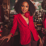 woman standing at a bar wearing red french blazer