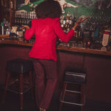 girl in a bar with her back turned wearing red
