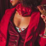 Woman in a red jacket holding a glass of champagne with a blurred background