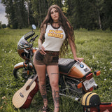 Woman standing next to a motorcycle in a grassy field with 'Stop Wars' shirt and shorts made and designed by Soul Sister since 1969
