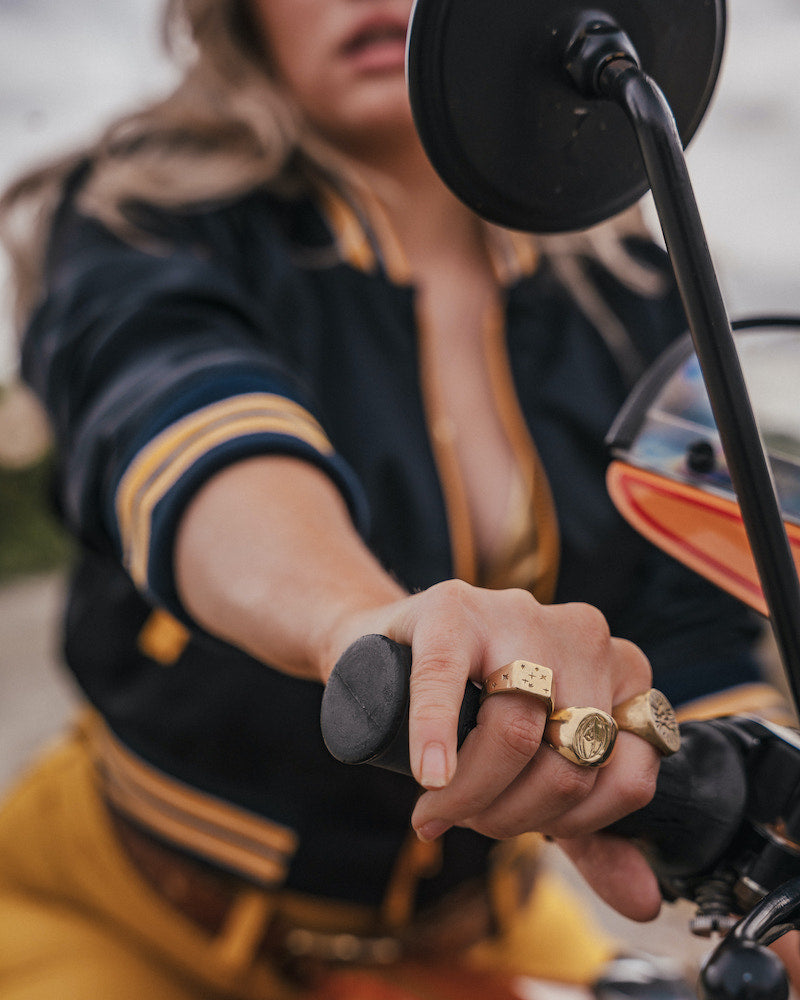 Person wearing gold rings on a motorcycle wearing Soul Sister since 1969 