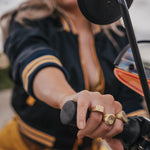 Person wearing gold rings on a motorcycle wearing Soul Sister since 1969 