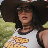 Person wearing a 'Top Wars' tank top and large hat in a field. Designed by Soul Sister since 1969