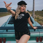 Woman posing in front of a vintage car on a road trip