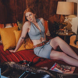 Woman sitting on a bed with a record player and vinyl records in a cozy room.