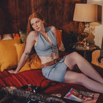 Woman sitting on a couch in a cozy room with a lamp and records.