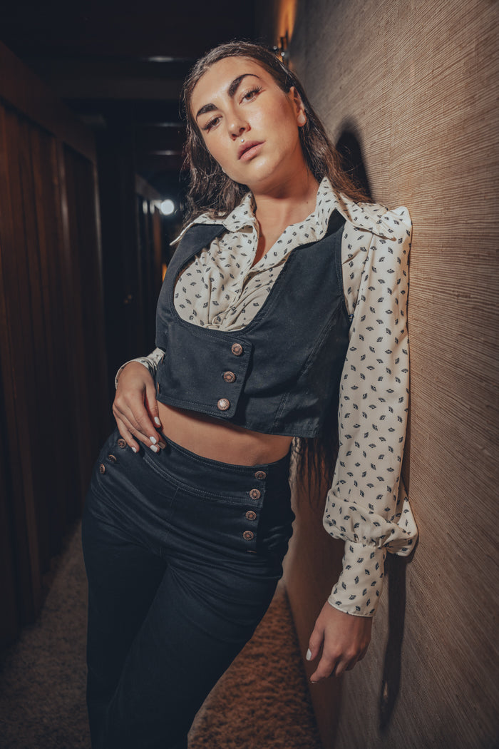 vintage vibes as a woman rocks a black waistcoat and bell bottoms i a soulful retro inspired home