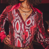 Person wearing a patterned red and black shirt with a blurred background