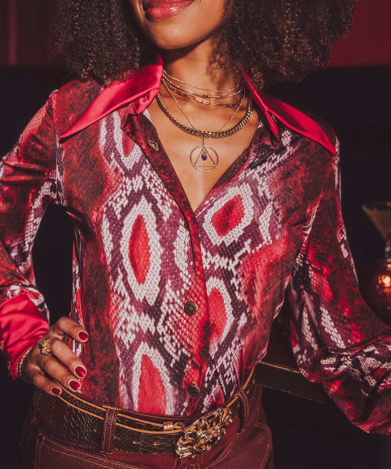 Person wearing a patterned red and black shirt with a blurred background