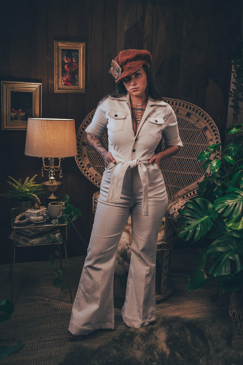 Woman wearing a cream corduroys 70s jumpsuit with flared legs and wrapped her collar handmade by Soul sister since 1969