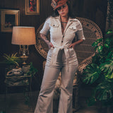Woman wearing a cream corduroys 70s jumpsuit with flared legs and wrapped her collar handmade by Soul sister since 1969